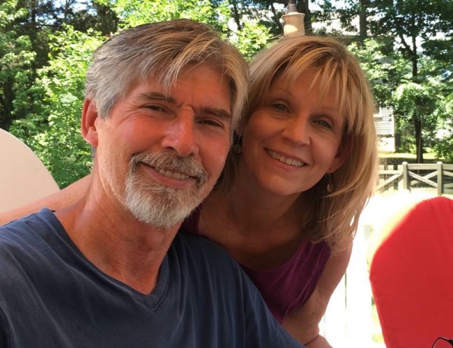 Amy's mom and dad smiling during a father's day BBQ on their back deck.
