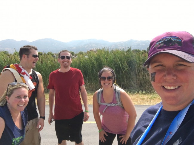 Friends taking selfies while waiting to cheer Amy on when she crosses the finish line.