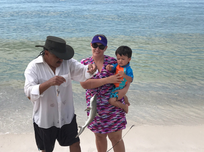 Popo showing Conner and Tracie the shark he caught in Orange Beach.